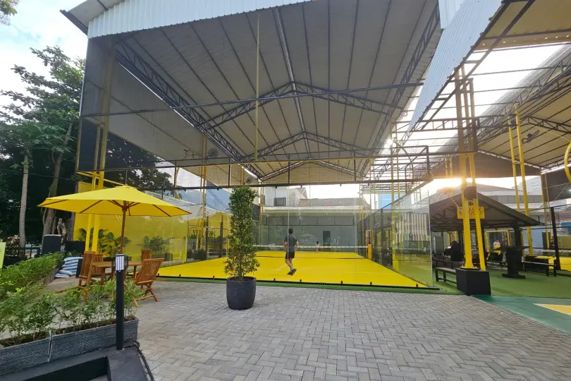 Patio with yellow umbrellas beside the courts