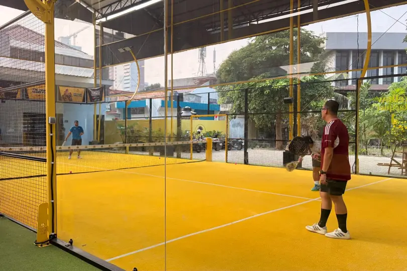 Players on a yellow padel court